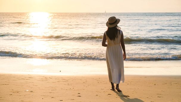 Aasian Thai naiset mekko kävellä rannalla auringonlaskun aikana Khao Lak Thaimaassa.  - Valokuva, kuva