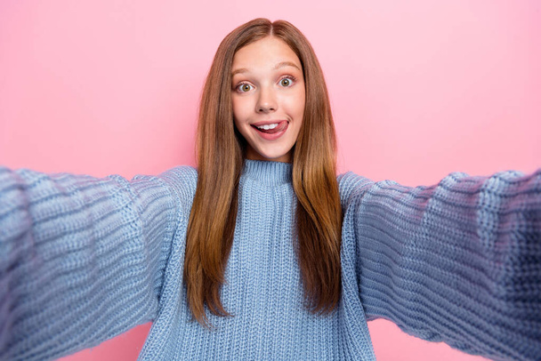 Selfie closeup photo of young brown hair teen girl lick teeth tongue out funky face video recording blog isolated on pink color background. - Фото, зображення