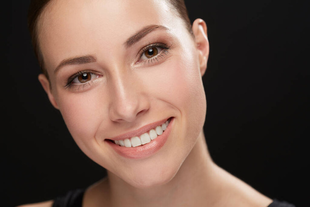 Flawless Skin. Cropped view of a naturally beautiful young brunette smiling against a black background - Φωτογραφία, εικόνα