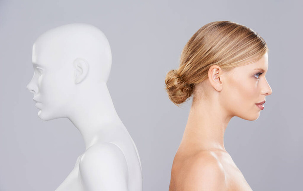Turning your back on the problem. Studio shot of a woman with her back facing a plastic mannequin - Foto, Imagen