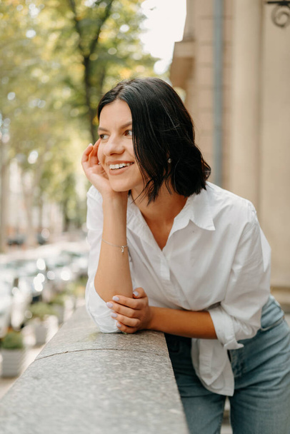 Outdoors portrait of a nice short hair woman wearing white shirt smiling and dreaming in summer. - Foto, Imagen