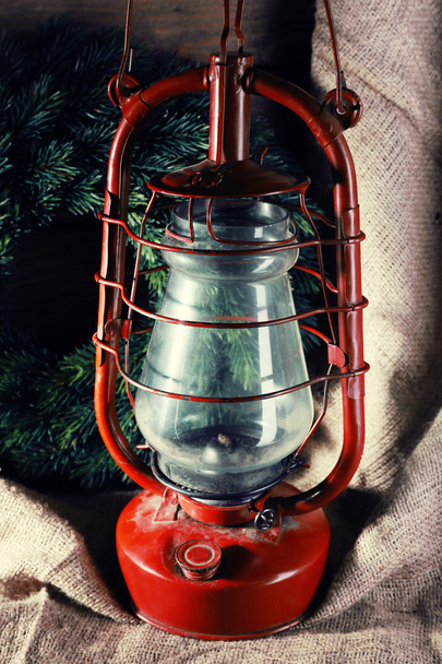 Kerosene lamp with wreath on wooden planks background - Фото, изображение