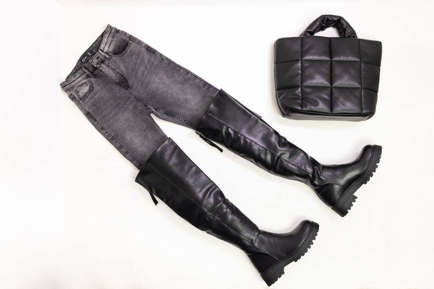 nature morte de jeans gris, bottes noires et sac à main noir - Photo, image
