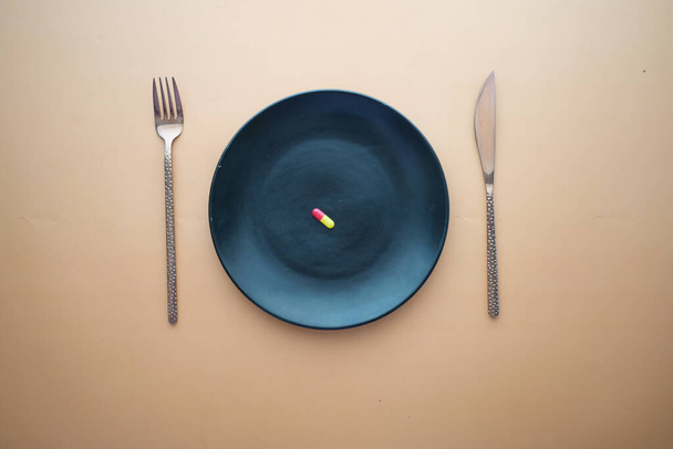 top view of a single capsule on a plate on table . - Photo, Image