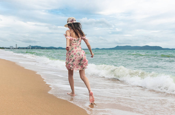 Young barefoot woman walking on the sand beach, travel and vacation concept. - Foto, Imagem
