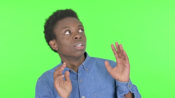 Casual African Man Feeling Scared, Frightened on Green Background - Imágenes, Vídeo