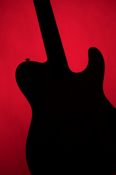 Gitarrensilhouette isoliert auf Rot - Foto, Bild