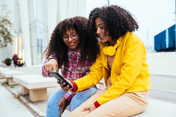 jóvenes mujeres felices divirtiéndose al aire libre, riendo y compartiendo buen humor. Adolescentes amigos pasar tiempo al aire libre en Barcelona - Foto, imagen