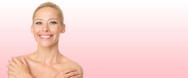 Beautiful blonde with perfect skin on pink background. - Foto, afbeelding