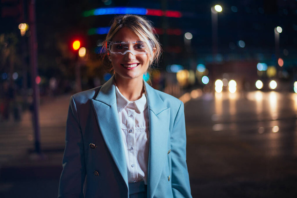 business woman with cyborg bionic arm and augmented reality visor. Representation of the future that will include human being and tech parts - cyberpunk look  - 写真・画像