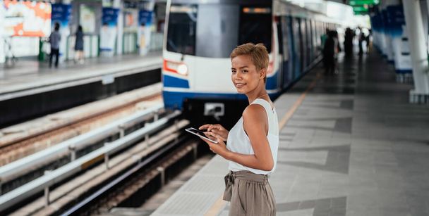 From above Photo of Happy Woman Using A Digital Tablet while Standing at Railway Platform - Фото, зображення