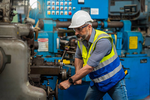 Techniker mit Handschuhen, Helmen, die in einer Industriefabrik arbeiten. Rüde mit Schutzhandschuhen schweißt in einer Fabrik. - Foto, Bild