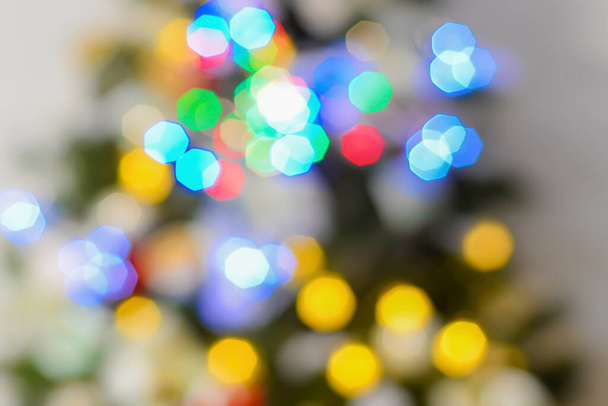 Bokeh hexagonal coloré lumineux à partir de lumières sur un fond de taches floues colorées à partir de guirlandes lumineuses.Fond de vacances coloré. - Photo, image