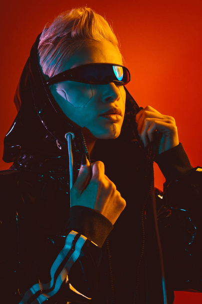 Representation of a bionic super human with advanced technology parts as vr visors and gadgets playing in a mixed reality training room. Futuristic cyberpunk evolution of human mankind and AI - Photo, Image