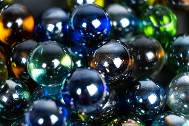 Veel blauwe en groene glazen ballen, kralen op een witte achtergrond, close-up. - Foto, afbeelding