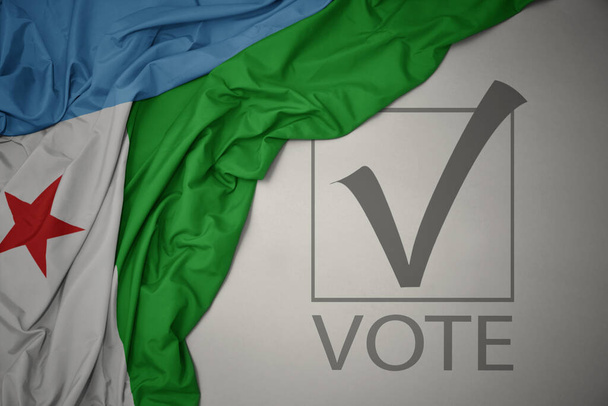 ondeando colorida bandera nacional de djibouti sobre un fondo gris con voto de texto. concepto de elección. Ilustración 3D - Foto, imagen