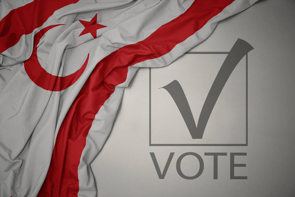 ondeando colorida bandera nacional del ciprus del norte sobre un fondo gris con voto de texto. concepto de elección. Ilustración 3D - Foto, imagen