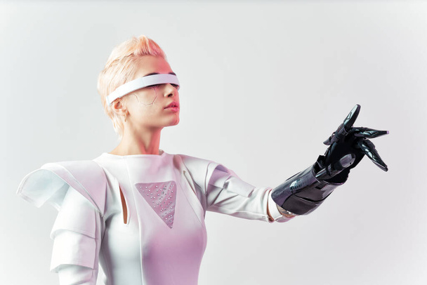 Representation of a bionic super human with advanced technology parts as vr visors and gadgets playing in a mixed reality training room. Futuristic cyberpunk evolution of human mankind and AI - Foto, Bild