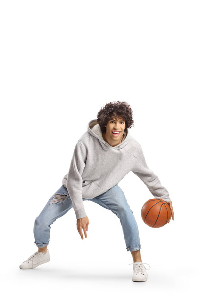 Young man in jeans playing basketball isolated on white background - Foto, Imagen