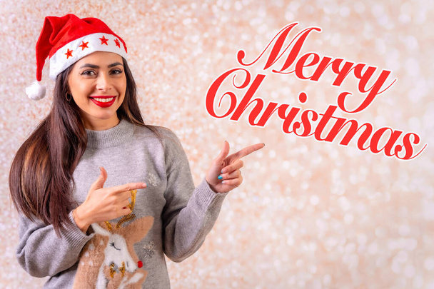 Brunette woman in christmas, gray christmas and happy new year sweater, pointing merry christmas - Foto, Imagen
