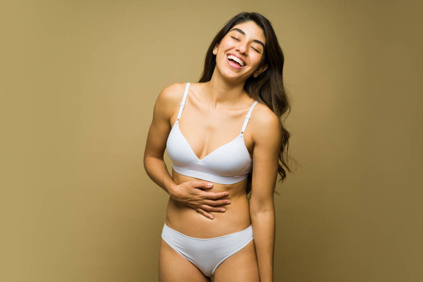 Beyaz iç çamaşırlı mutlu Meksikalı kadın gülüyor ve vücut kabullenmesi ve kendini beğenme ile eğleniyor.  - Fotoğraf, Görsel