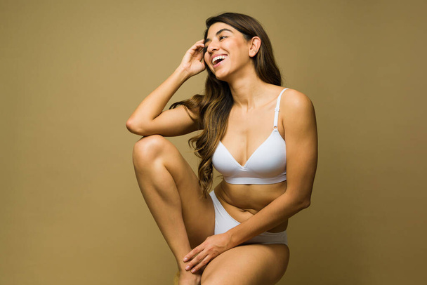 Cheerful young woman in underwear laughing and promoting self love and body acceptance  - Foto, imagen