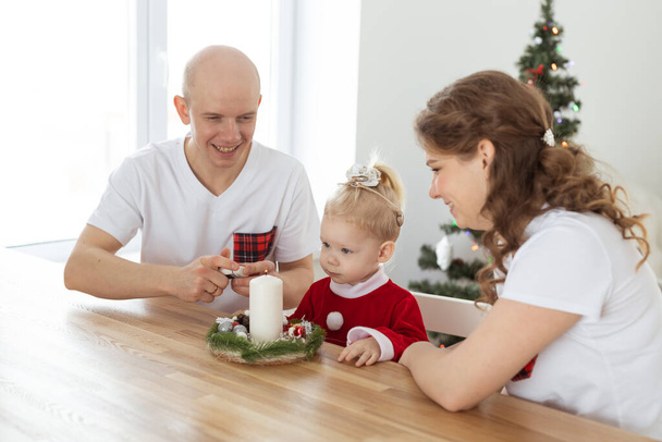 Baby child with hearing aid and cochlear implant having fun with parents in christmas room. Deaf and health - Fotografie, Obrázek