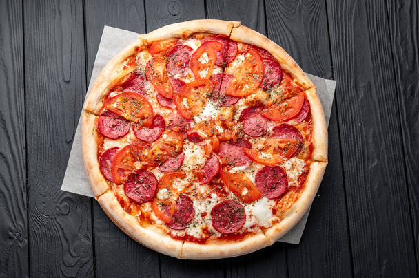 Smaczne pepperoni pizza i składniki gotowania pomidory bazylia Top view of hot pizza. - Zdjęcie, obraz