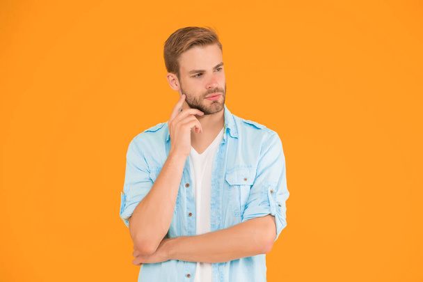 thoughtful guy has groomed hair on yellow background. human emotions. sexy boy with trendy hairstyle wear shirt. handsome unshaven man with bristle. male summer casual fashion style. sexy macho man. - Photo, Image