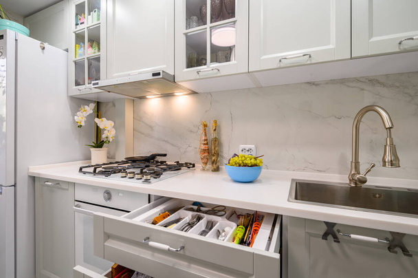 Primo piano al bianco e grigio nuovo moderno ben progettato piano di lavoro della cucina, alcuni cassetti tirato fuori - Foto, immagini