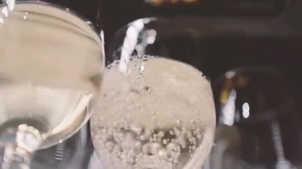 A pincér fehérbort önt a poharakba. A csapos pezsgőt önt a poharakba a vendégek számára az ünnepségen. - Felvétel, videó