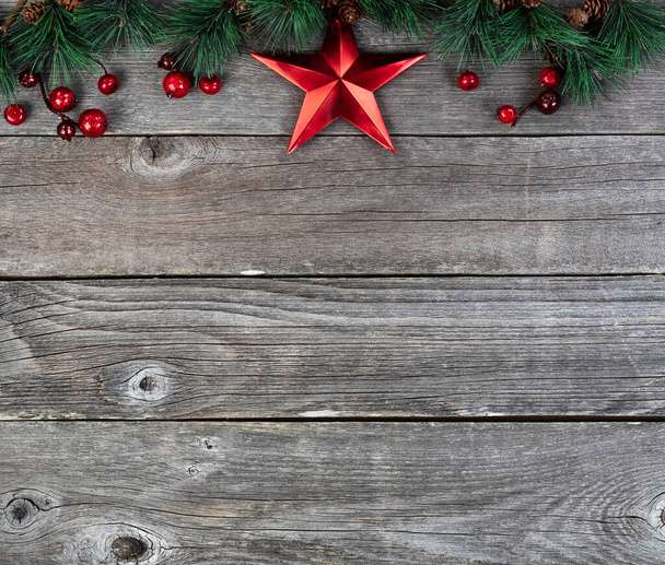 Veselé Vánoce nebo šťastný Nový rok pozadí s jedle tip větve a červená hvězda dekorace na rustikálním dřeva desky  - Fotografie, Obrázek