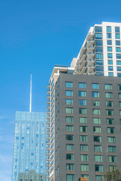 Außenansicht eines Wohnkomplexes in der Innenstadt von Austin, Texas. Stadtsilhouette mit Wohnungen oder Büros vor wolkenlosem blauen Himmel. - Foto, Bild