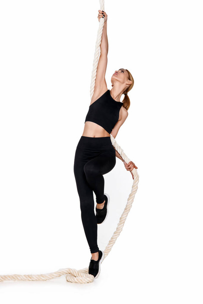 Sporty slim blonde woman in sportswear with rope on white background - Photo, Image