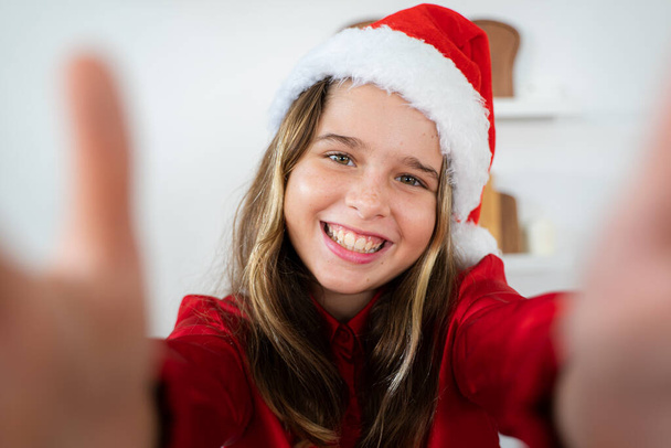 Little girl with big smile looking at the camera and celebrating christmas with family,Cheerful family with santa hats,Merry Christmas and Happy Holidays. - Foto, immagini