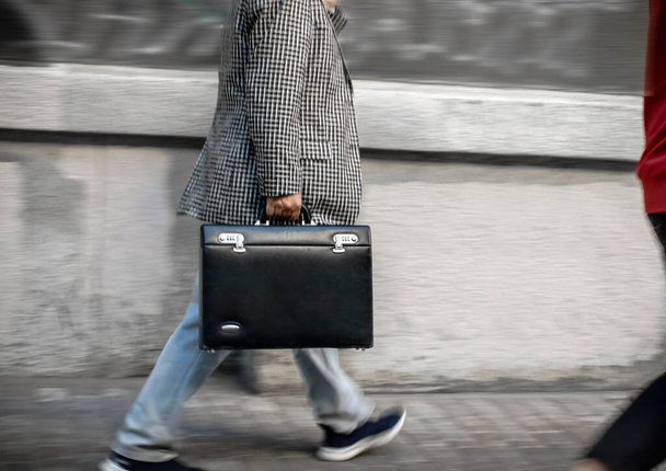 Motion blur force, a man walks with a briefcase down the street - Φωτογραφία, εικόνα