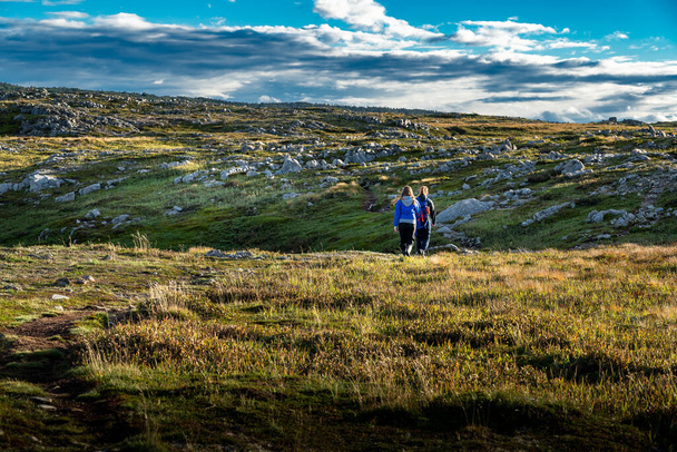 ニューファンドランド・カナダのクロンダイク・トレイル沿いの苔むしたツンドラを歩く母親と娘. - 写真・画像