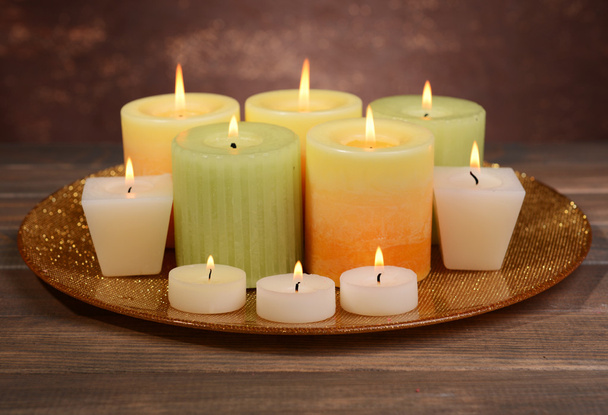 Beautiful candles on table on brown background - Fotoğraf, Görsel