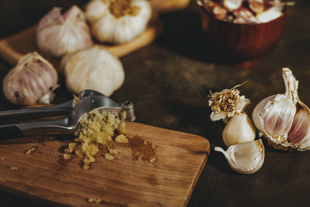 Garlic press with garlic cloves - Фото, изображение