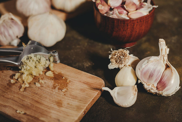 Garlic press with garlic cloves - Foto, Bild