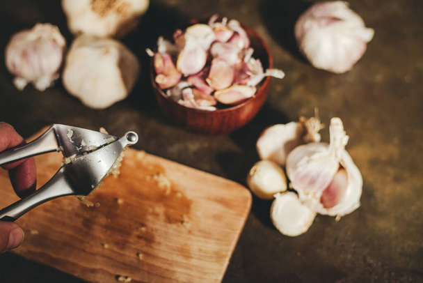 Garlic press with garlic cloves - Zdjęcie, obraz