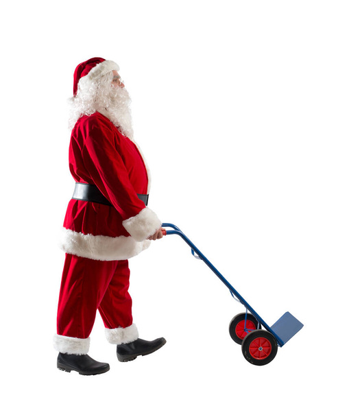 Санта Клаус толкает тележку с посылками, чтобы доставить - Фото, изображение