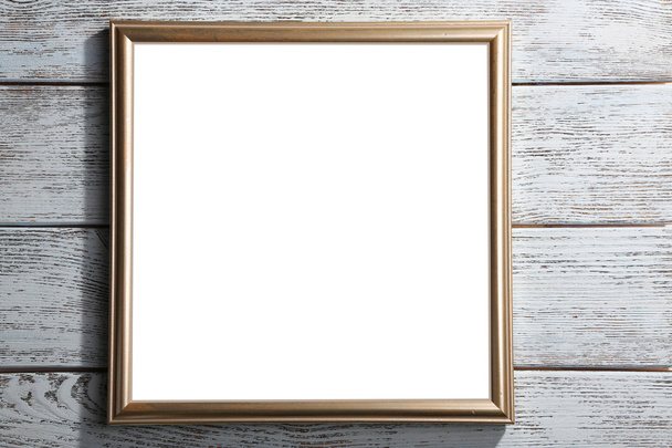 Golden photo frame on color wooden background - Photo, image