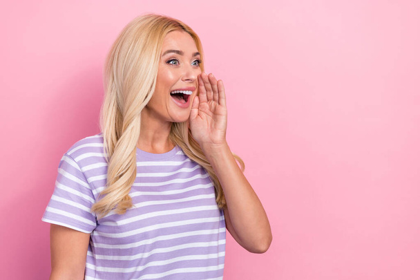 Photo of young excited overjoyed crazy woman wavy blonde hair hand cheek scream loud information empty space isolated on pink color background. - Foto, afbeelding
