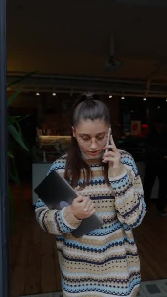 Жінка розмовляє по телефону, поки виходить з кафе
 - Кадри, відео