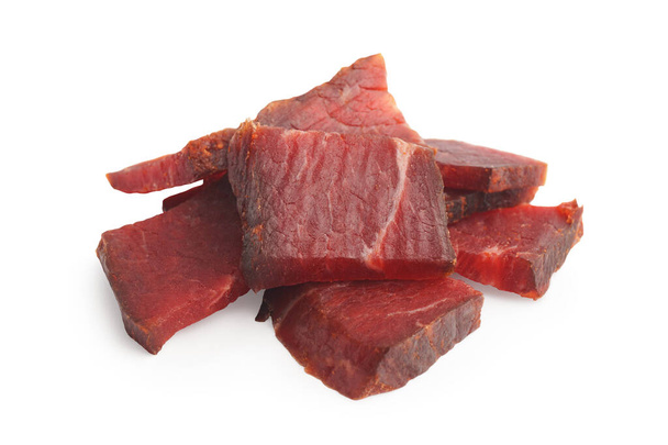 Pieces of delicious beef jerky on white background - Foto, immagini