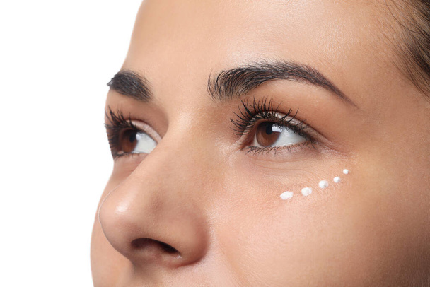 Woman with eye cream on white background, closeup. Skin care - Photo, image