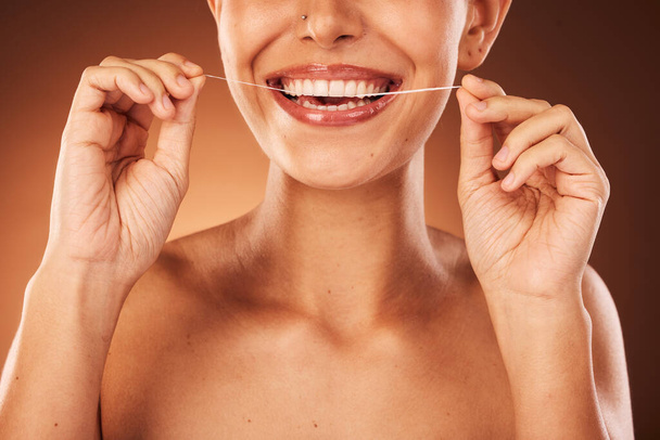 Teeth, zoom and woman with floss for dental cleaning, teeth whitening and healthy mouth protection in studio. Smile, wellness or hands of girl flossing with thread for natural tooth shine, self care. - Foto, imagen