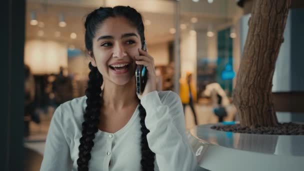 Lächelnd arabische Frau aus dem Nahen Osten Käuferin Kundin Studentin Geschäftsfrau ethnische Mädchen Dame verbringen Wochenende im Einkaufszentrum Business Center beantworten Handy-Anruf Gespräch freundliches Geschwätz per Telefon Klatsch und Tratsch - Filmmaterial, Video