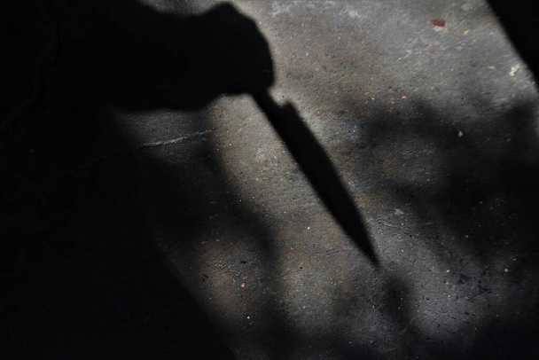 Silhouette of sad male holding knife. concept of killing - 写真・画像